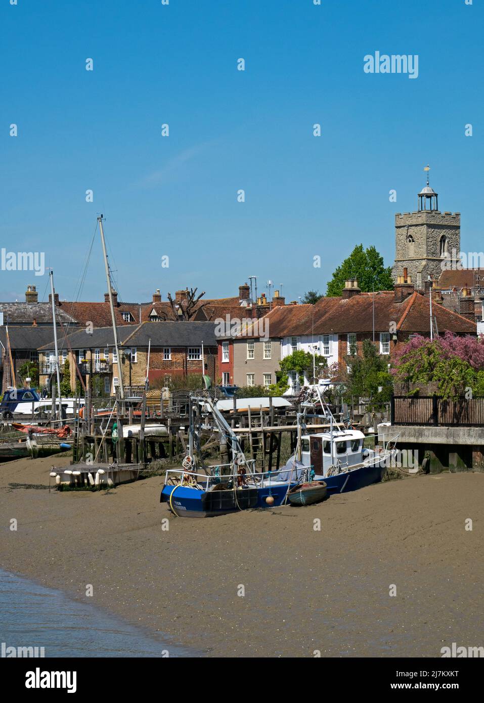 Boats Moored on the the beach front of the estuary of the River Colne, with the ancient buildings of town of Wivenhoe, Essex, England, UK Stock Photo