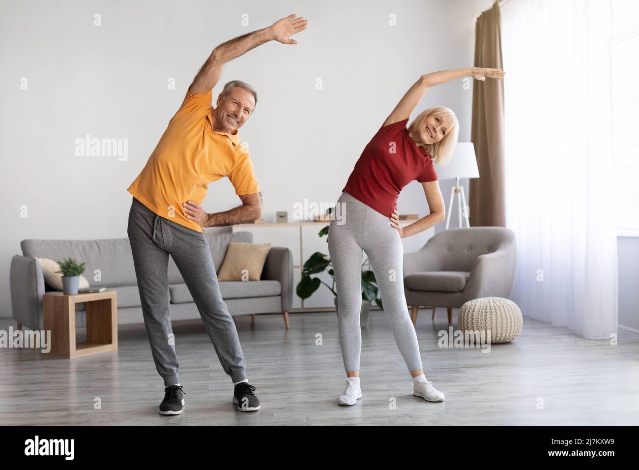 Positive mature couple having workout at home Stock Photo