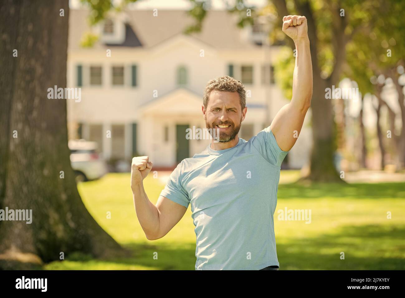 happy bearded man standing celebrating buying of house, home Stock Photo