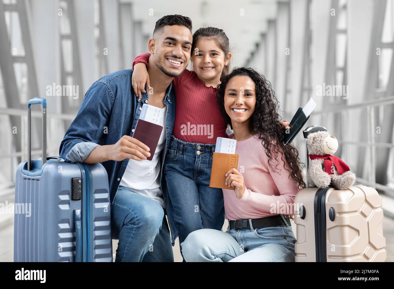 Happy arab parents and daughter relaxing in airport with baggage and tickets Stock Photo