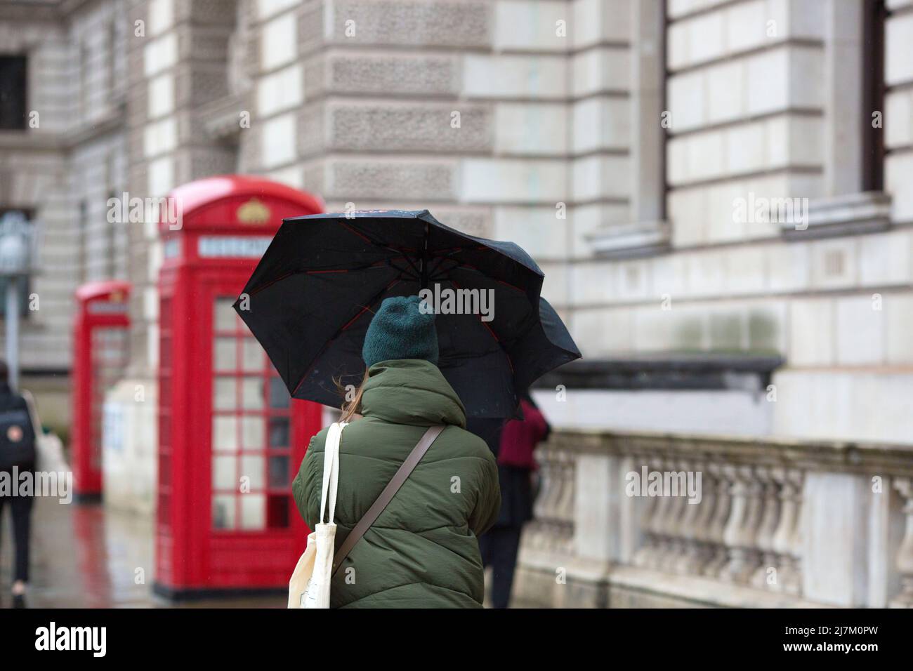 The umbrellas held by a pedestrian is seen blown by the wind in Westminster, central London. Stock Photo