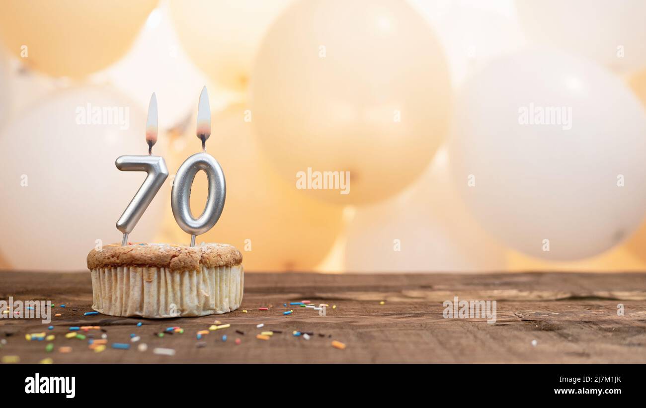 Happy birthday card with a candle in a cupcake against the background of balloons. Copy space happy birthday with cupcake digit Stock Photo