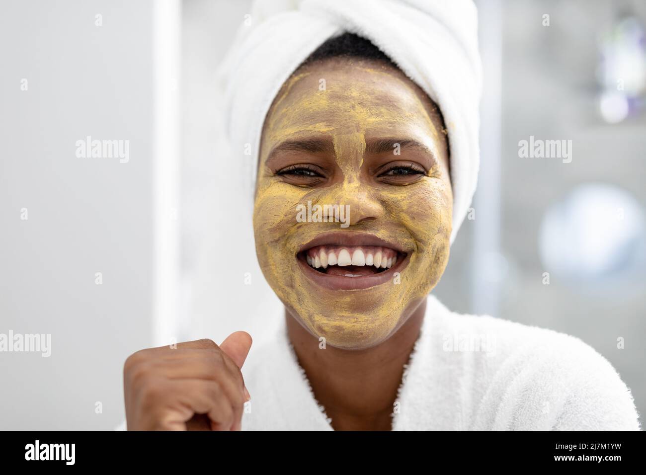 Close-up portrait of happy african american mid adult woman with face pack Stock Photo