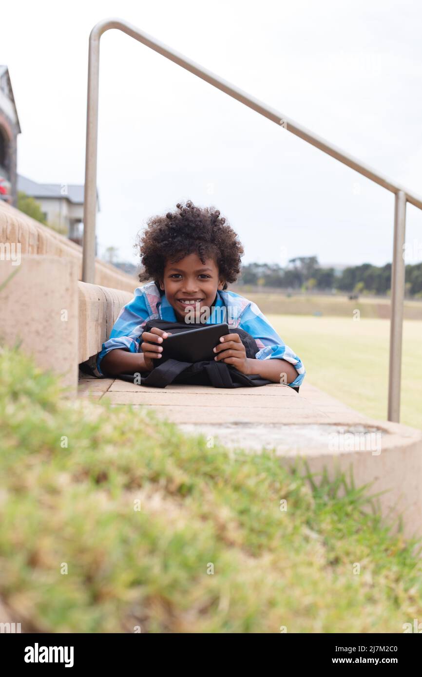Portrait of smiling african american elementary schoolboy with ...