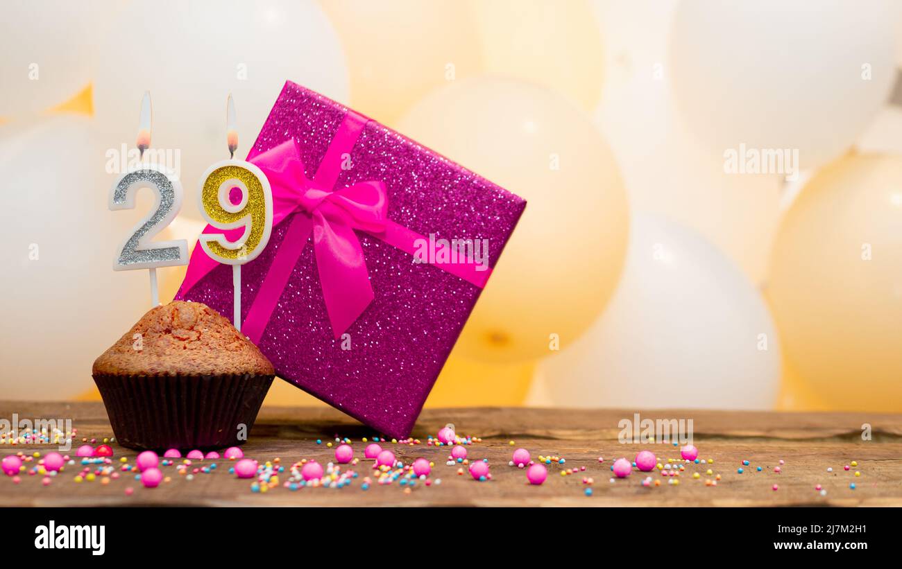 Happy birthday with pink gift box for baby girl. Beautiful birthday card with a cupcake and a burning candle Stock Photo