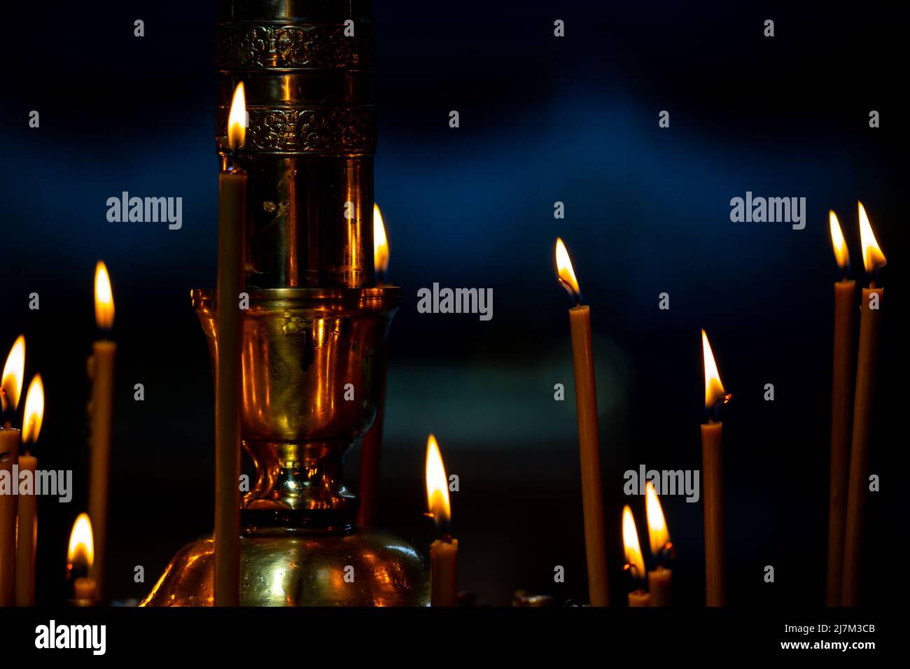 Candlestick with many burning candles in the dark interior of the
