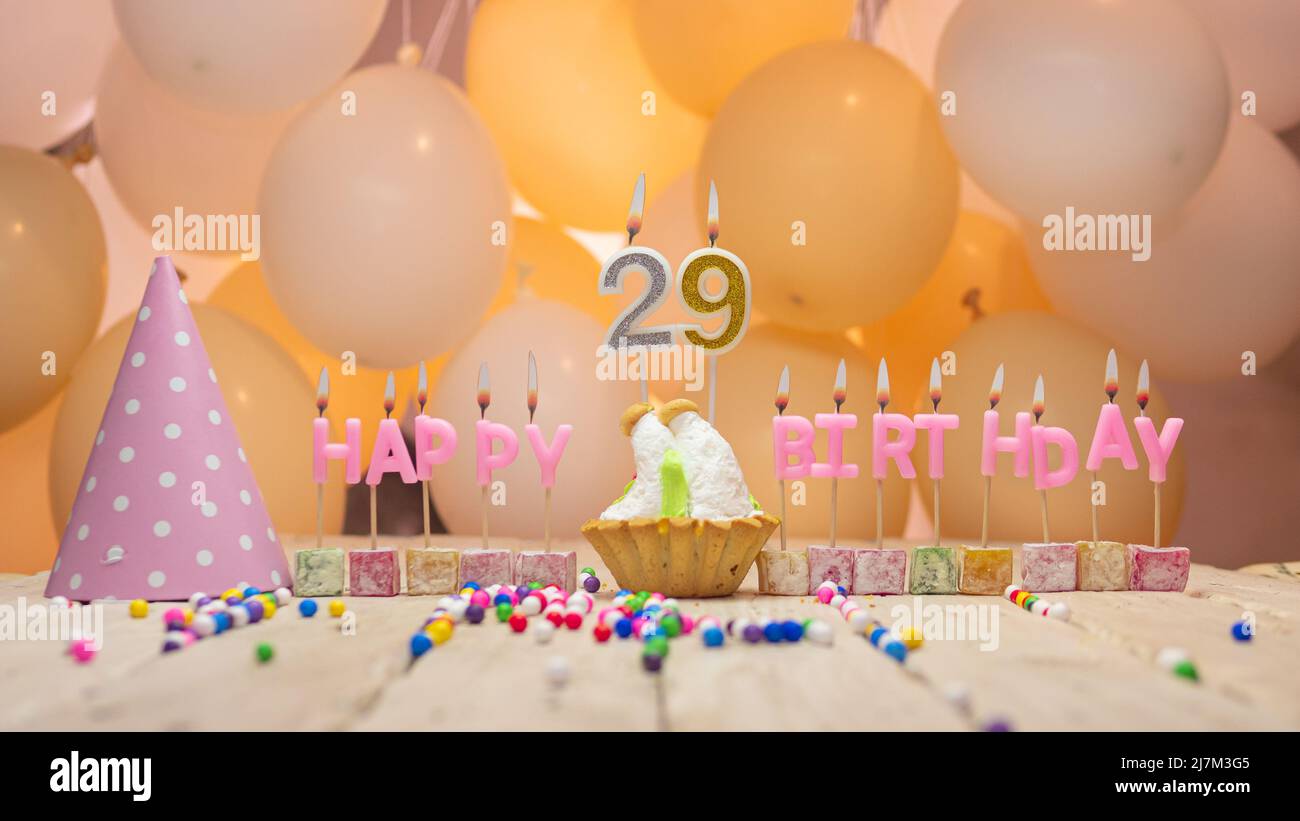 Beautiful background happy birthday number with lit candles, birthday candles in pink letters. Festive background with balloons Stock Photo