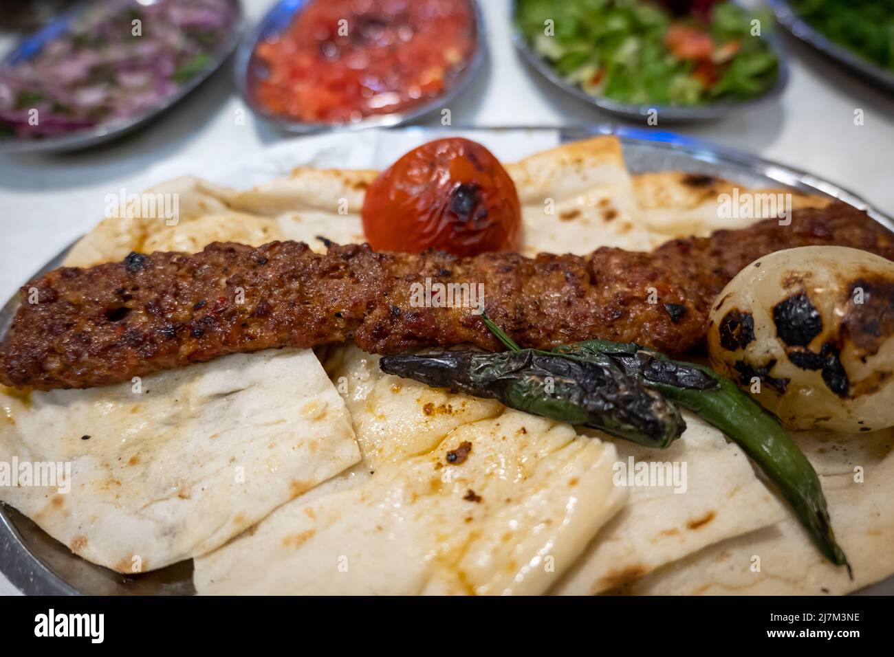 Adana Kebab, traditional Turkish cuisine with kebab meat, vegetables on the plate in Adana, Turkey Stock Photo