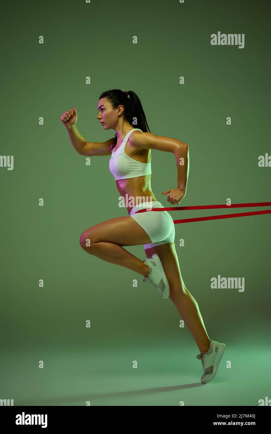 Inner String Running Full-length portrait of young sportive girl training, running with ...