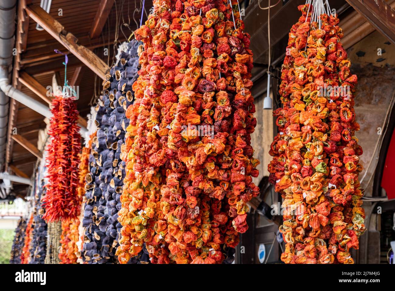Hanging dried peppers and tomatoes - sun dried marinated Turkish tomatoes, peppers and eggplants in the traditional bazaar at Gaziantep Stock Photo