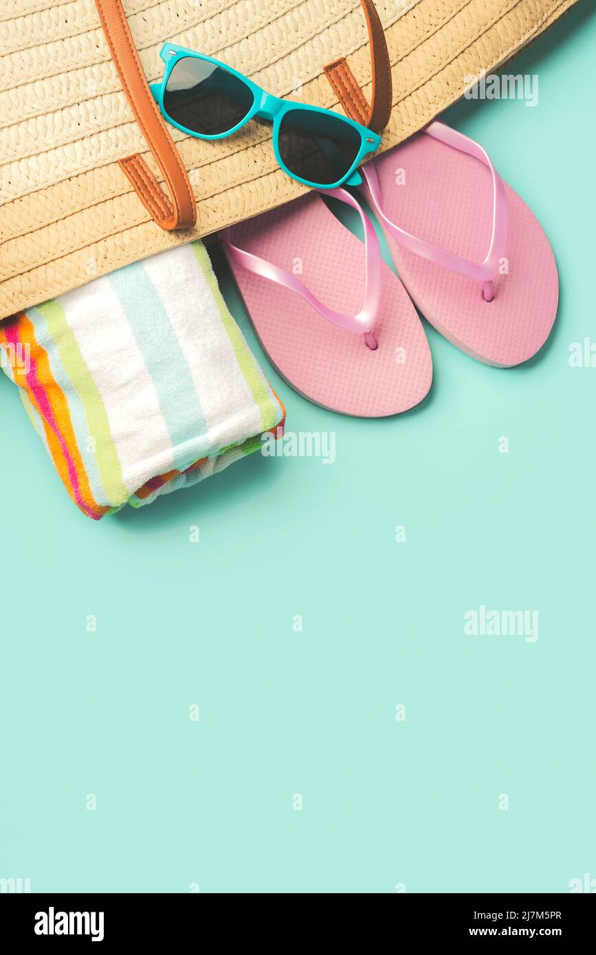 Summer holiday concept.Top view of beach bag with flip flops,beach towel,sunglasses and space for text over blue background Stock Photo