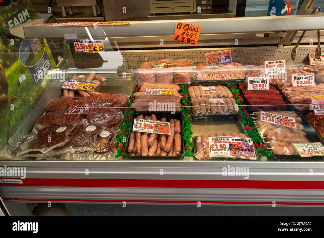 A view of a butchers chilled front display of meats and sausages in