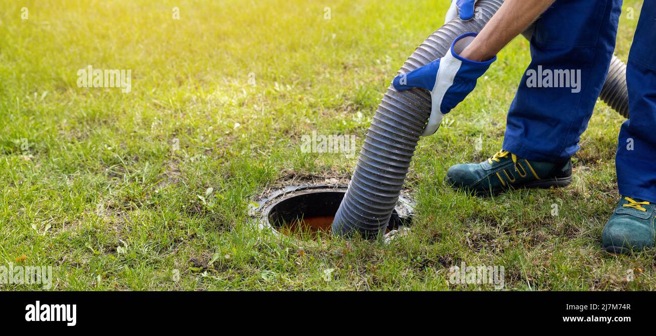 man pumping out house septic tank. drain and sewage cleaning service. copy space Stock Photo