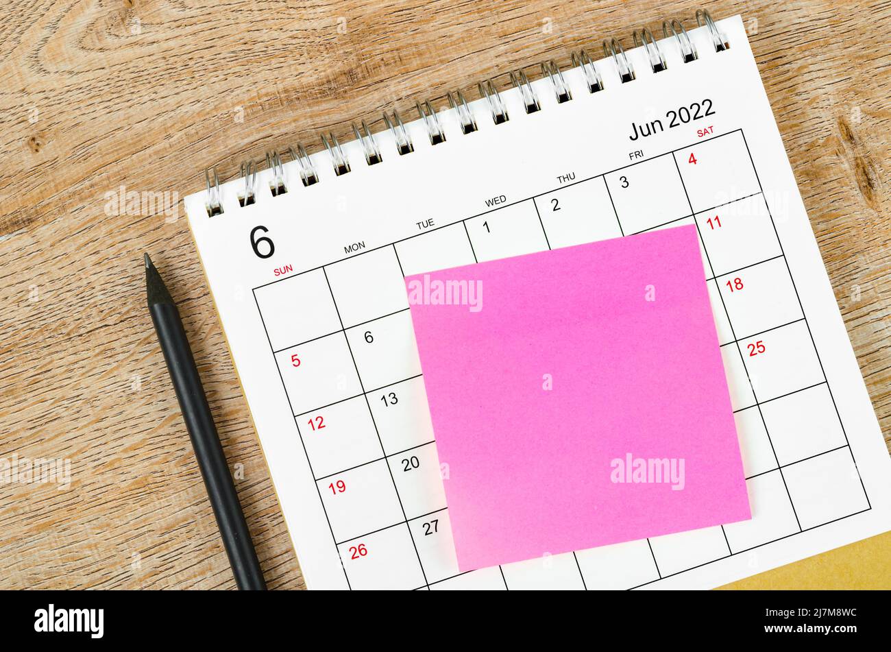 Blank sticky note on June 2022 desk calendar on wooden background for ...