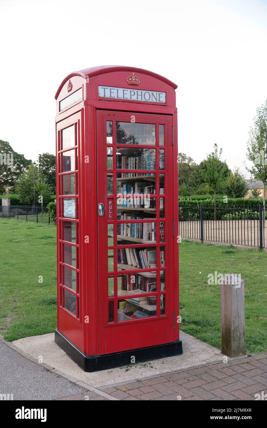 An iconic red British telephone box repurposed as a community library, Fairfield, Bedfordshire, UK Stock Photo