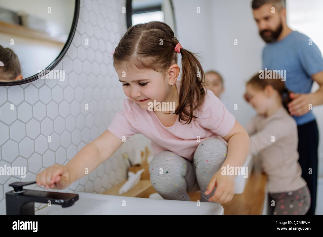Father with three little children in bathroom, morning routine concept. Stock Photo