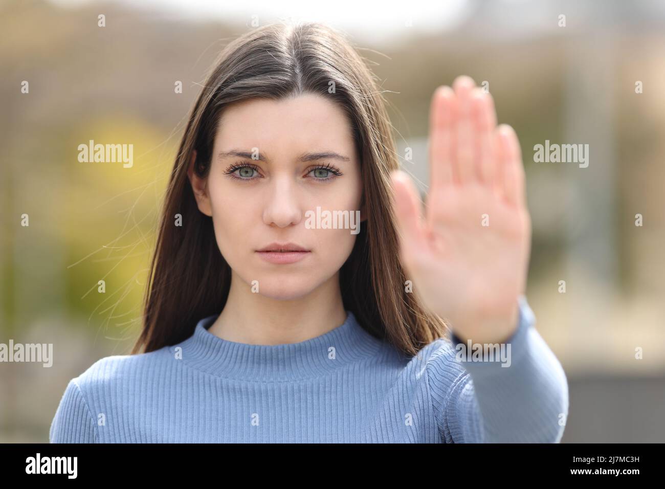 Front view portrait of an angry teen gesturing stop in a park Stock Photo