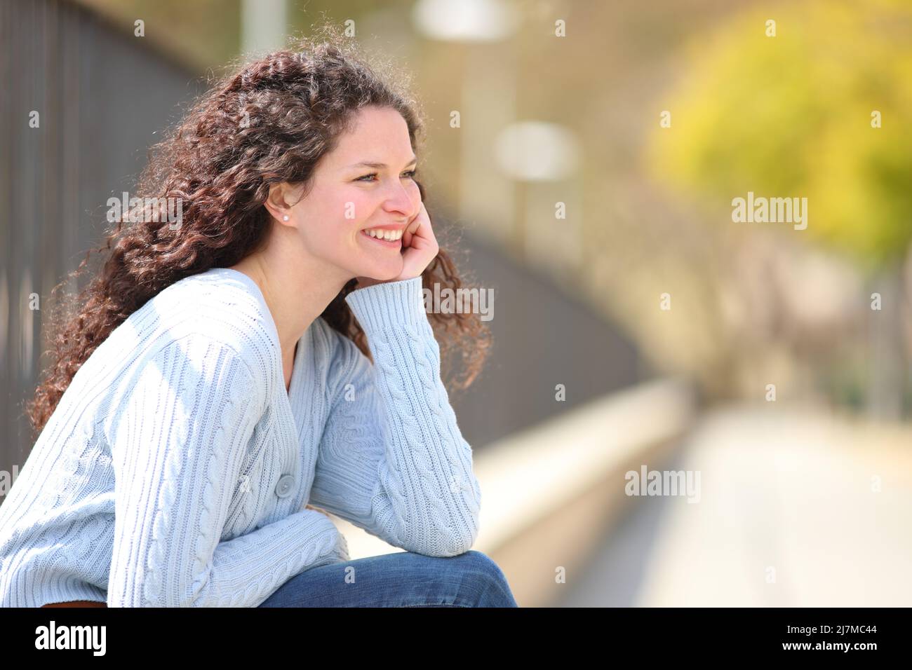 Happy woman contemplating and relaxing sitting in a park a sunny day Stock Photo