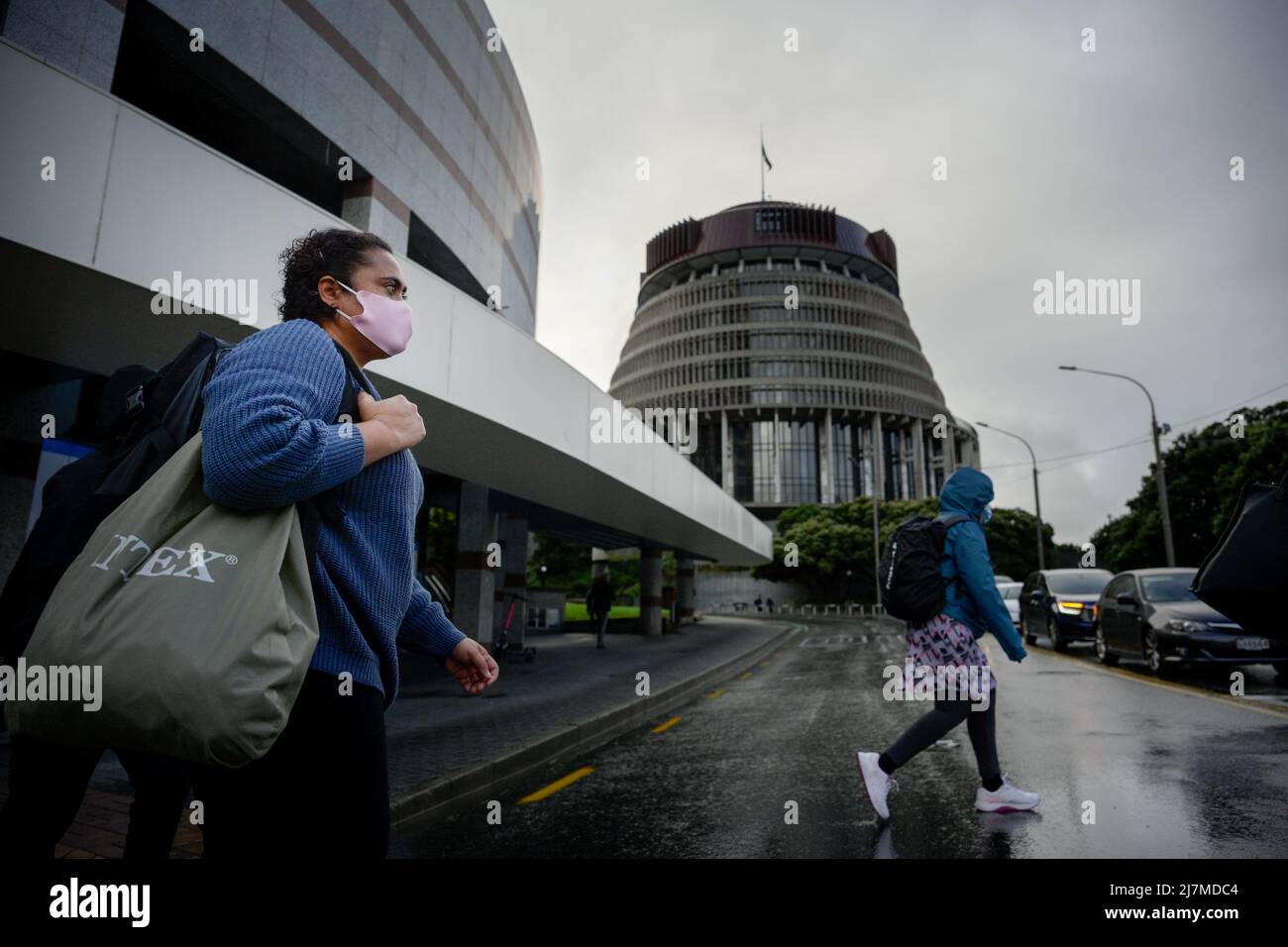 (220510) -- WELLINGTON, May 10, 2022 (Xinhua) -- People wearing masks walk pass Beehive, the Parliament building of New Zealand, in Wellington, New Zealand, May 10, 2022. New Zealand has reported 1,001,898 confirmed cases of COVID-19 since the beginning of the pandemic in early 2020, surpassing the one-million mark, the Ministry of Health said on Tuesday. (Xinhua/Guo Lei) Stock Photo