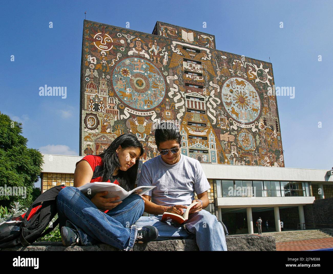 Mexico, Mexico City. Students in front of a mosaic by Juan O'Gorman at the Central Library of the Universidad Nacional Autonoma de Mexico, or UNAM uni Stock Photo