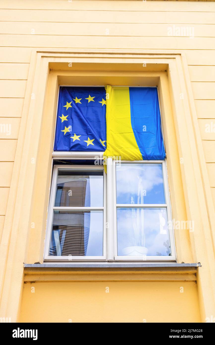 Ukraine and EU flag side by side in a window in Berlin as a sign of solidarity during the Ukraine Russia war, Germany, Europe Stock Photo