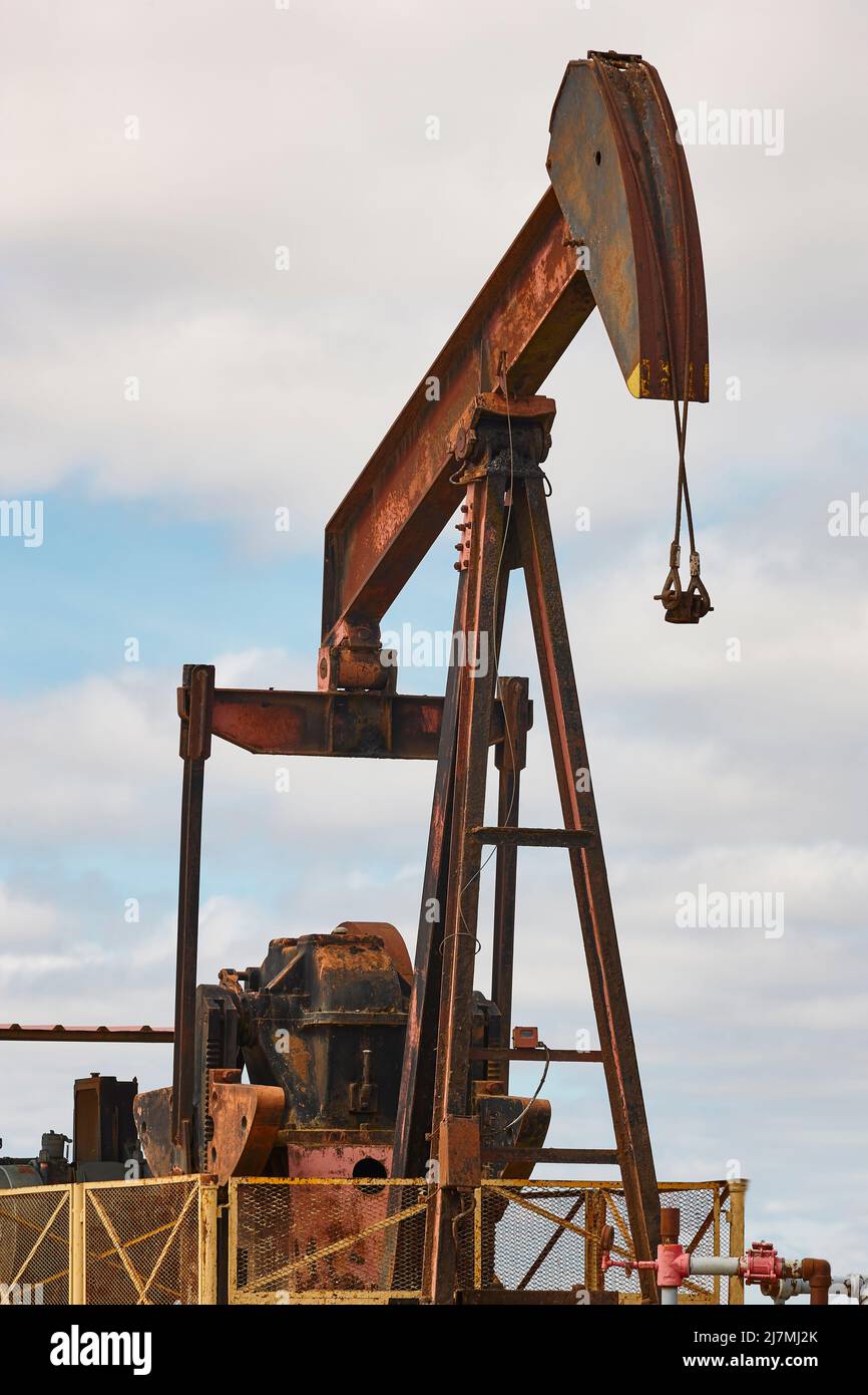Rusty oil pumping machine. Pump jack in Ayoluengo, Burgos. Spain Stock Photo