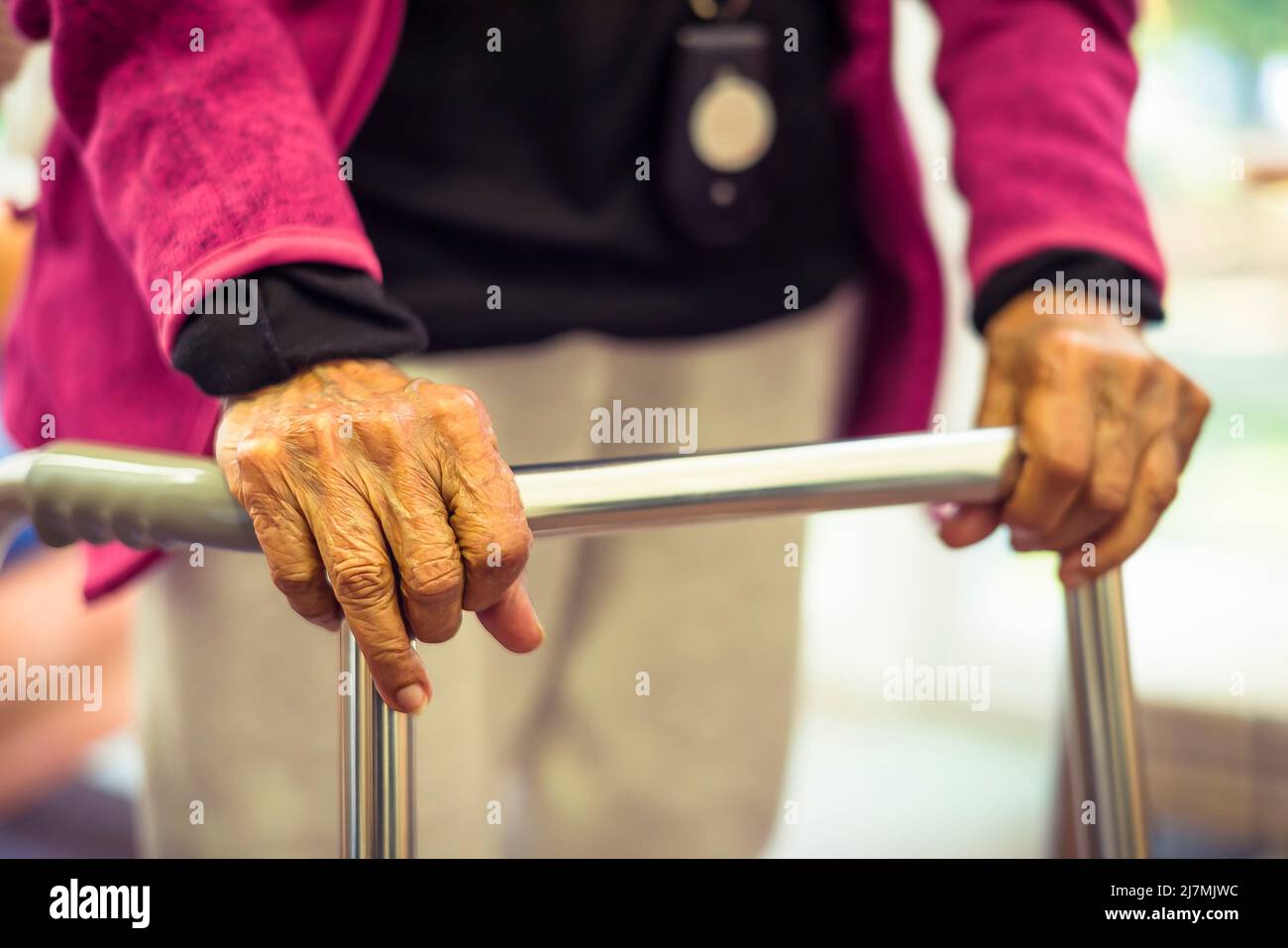 Old elderly Indian Asian woman walking with a Zimmer frame or walking frame, UK Stock Photo