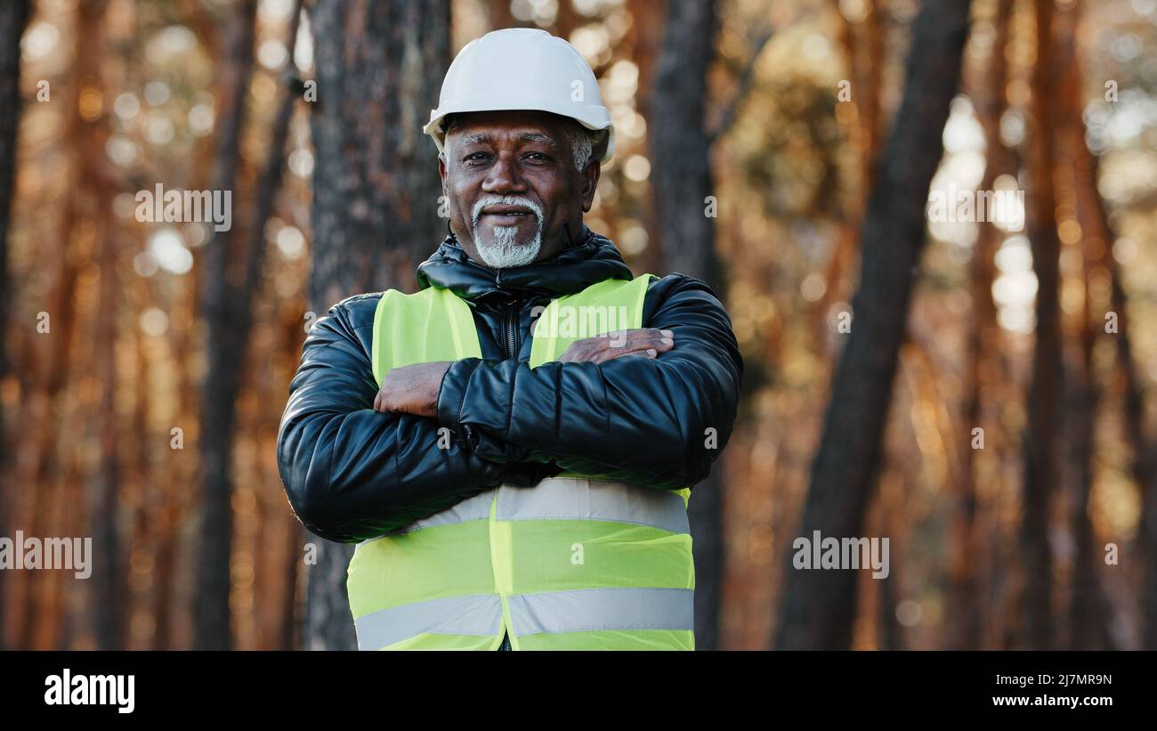 Mature african american confident male businessman standing outdoors professional forestry engineer foreman worker forester in uniform in protective Stock Photo