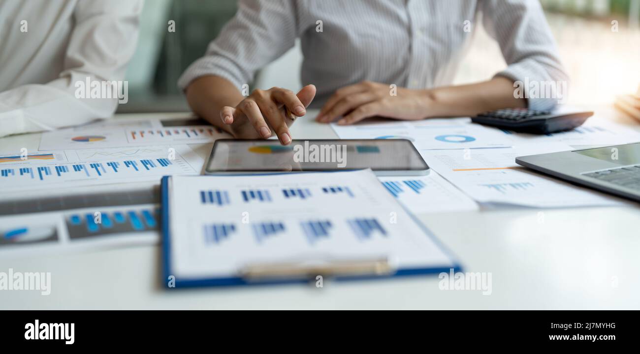 Business colleagues working and analyzing financial figures on a digital tablet Stock Photo