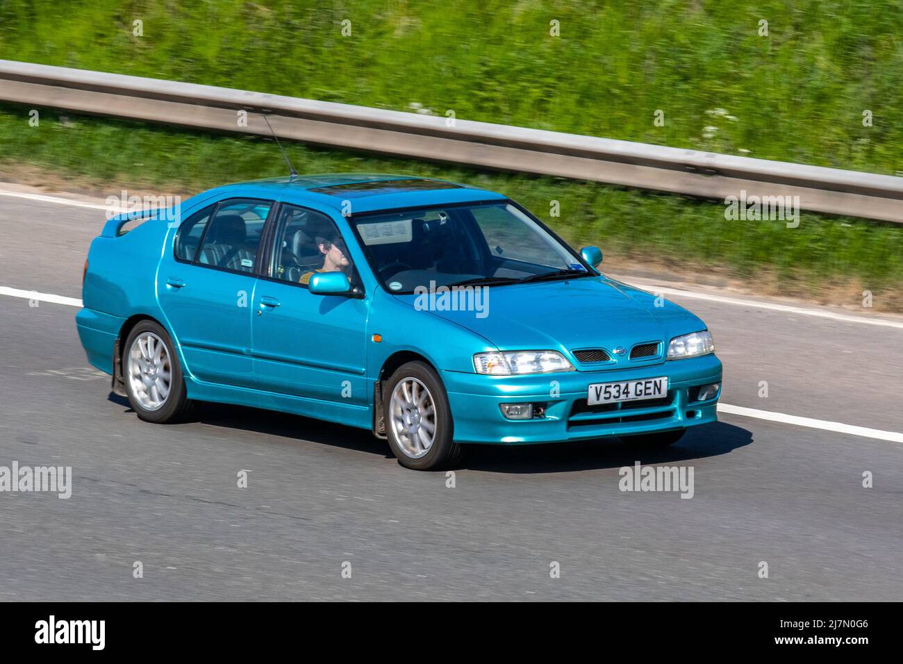 1999 90s nineties Blue Nissan Primera GR 16V 1998cc petrol 5-speed manual 4dr four-door; driving on the M6 in Manchester, UK Stock Photo