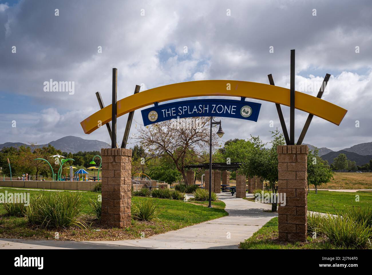 Winchester, CA, USA - April 11, 2022: Skinner Lake. Entrance bow over bow leading to Splash Zone, a kids playground with fountains under heavy blue cl Stock Photo