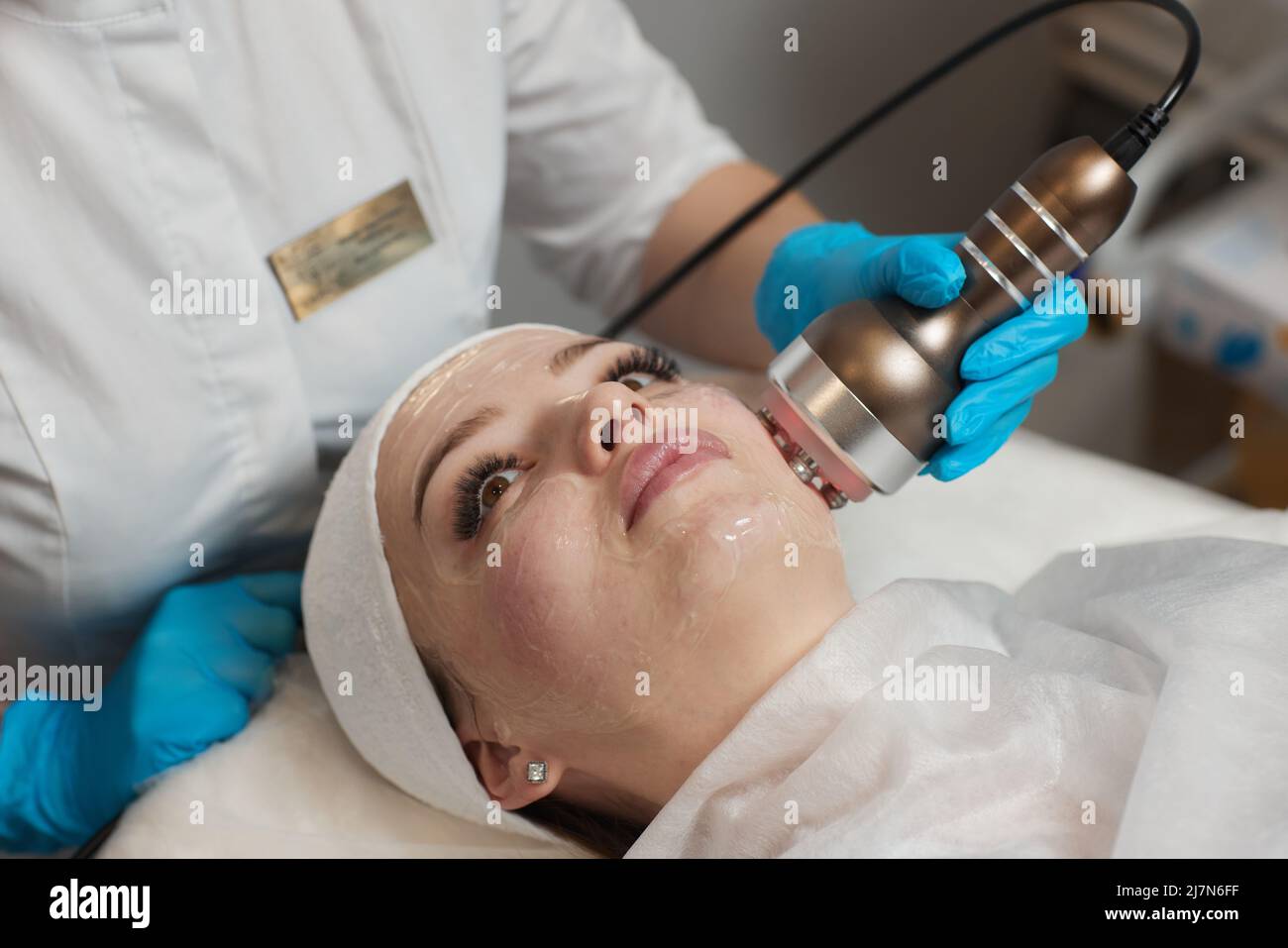 LED light anti-aging mask for facial skin care in a spa slow motion. A woman lies on a couch in a special mask. Modern technologies of beauty and heal Stock Photo
