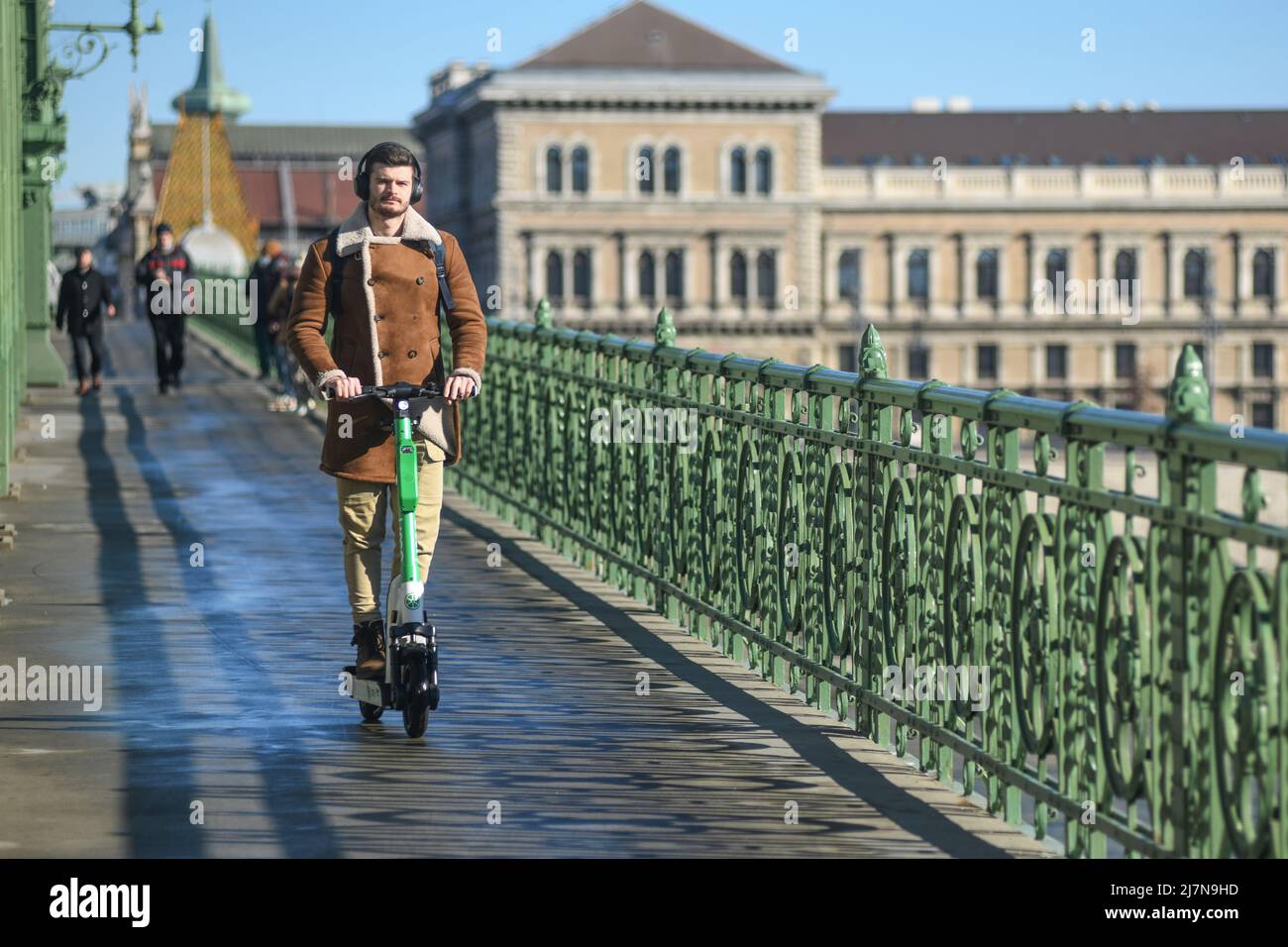 Hungarian man crossing the Liberty Bridge on a scooter. Budapest, Hungary Stock Photo