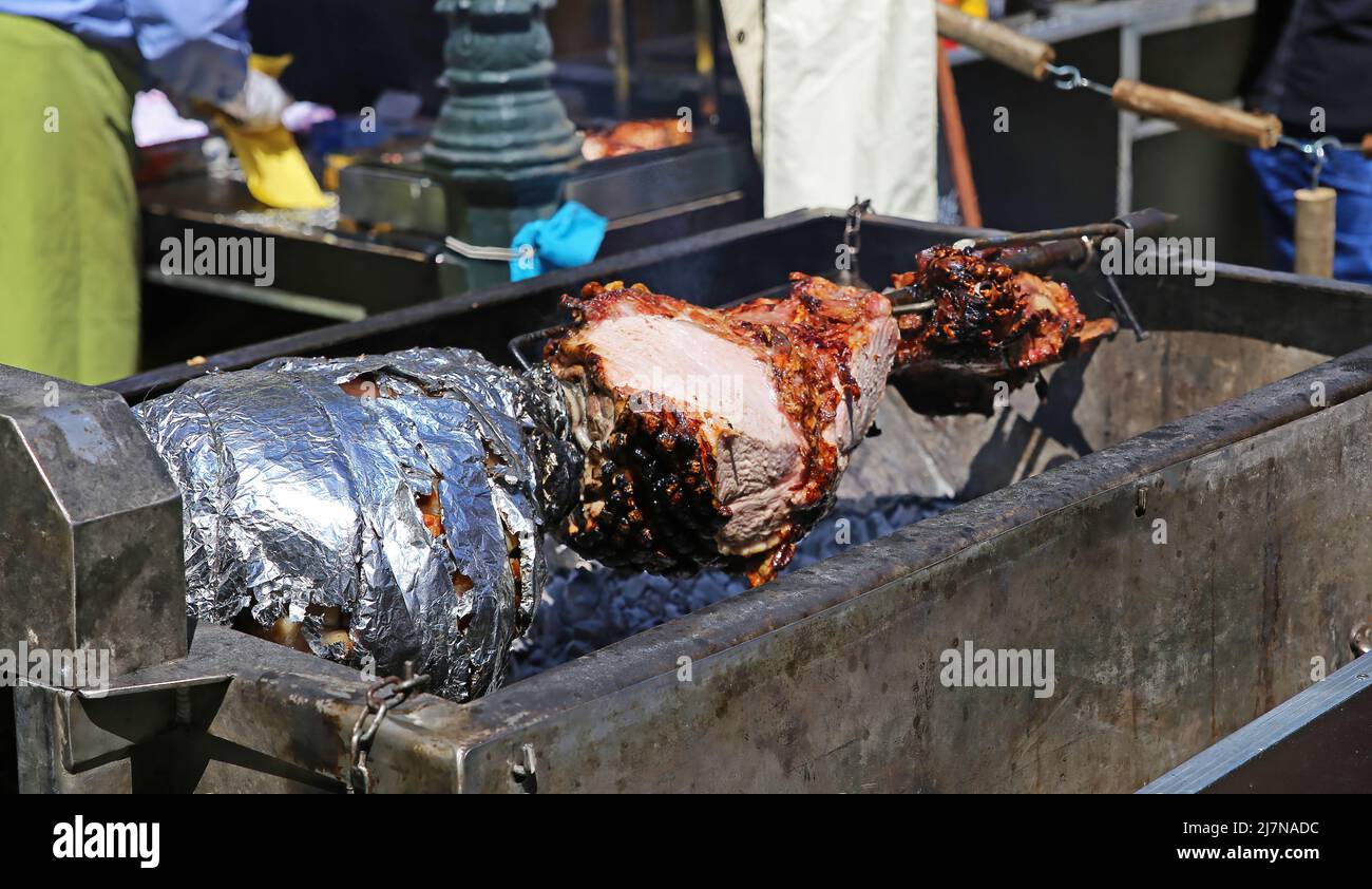 View on simple charcoal grill with spitroast meat on german farmers
