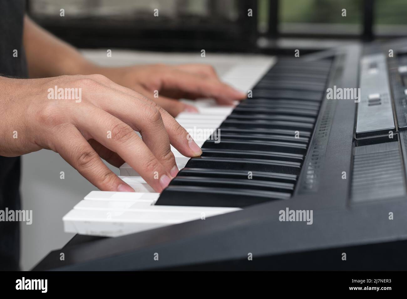 young latin man, playing musical piano notes on a synthesizer, boy  practicing high notes. detail shot of man creating new music and rhythms  Stock Photo - Alamy