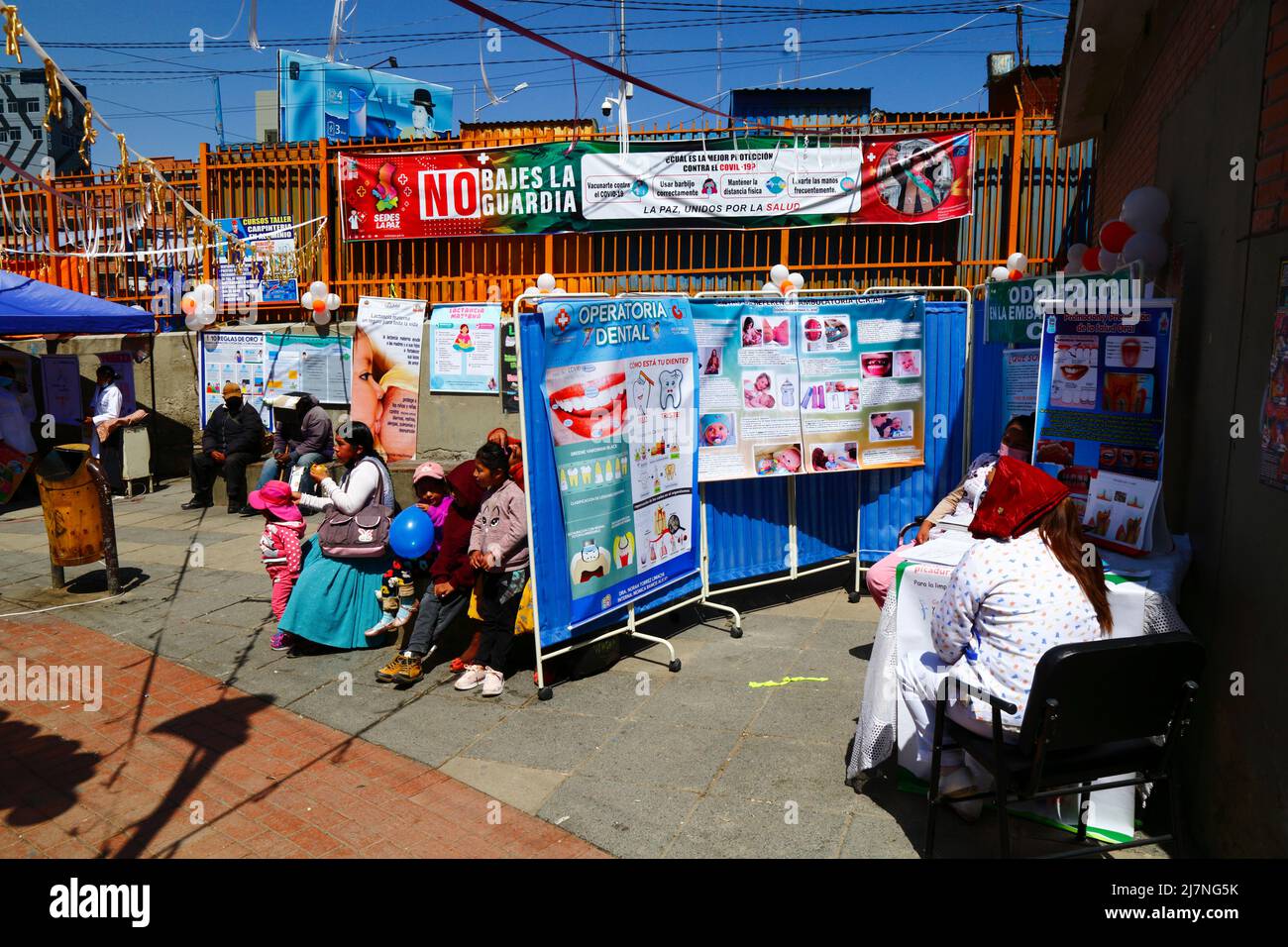 La Ceja, El Alto, Bolivia. 14th April 2022. A Bolivian family sits next to a temporary dental clinic at a health fair in El Alto. Stock Photo