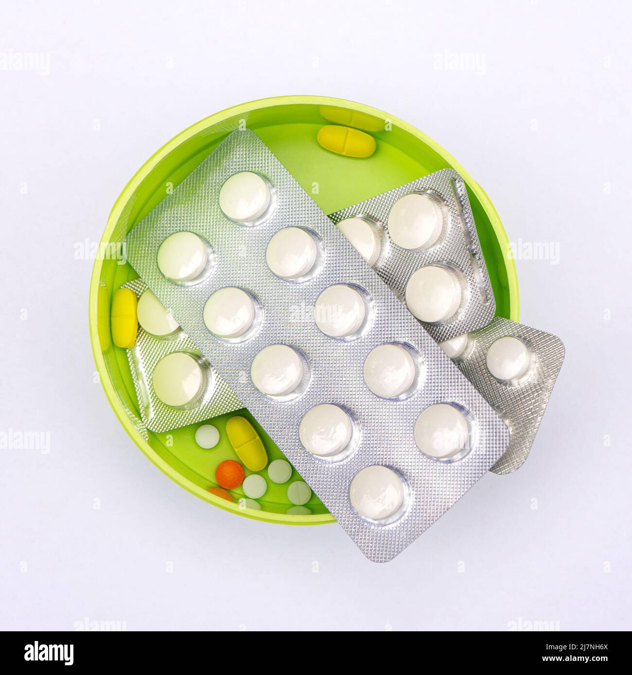 Multi-colored pills in a bright green box. Stock Photo