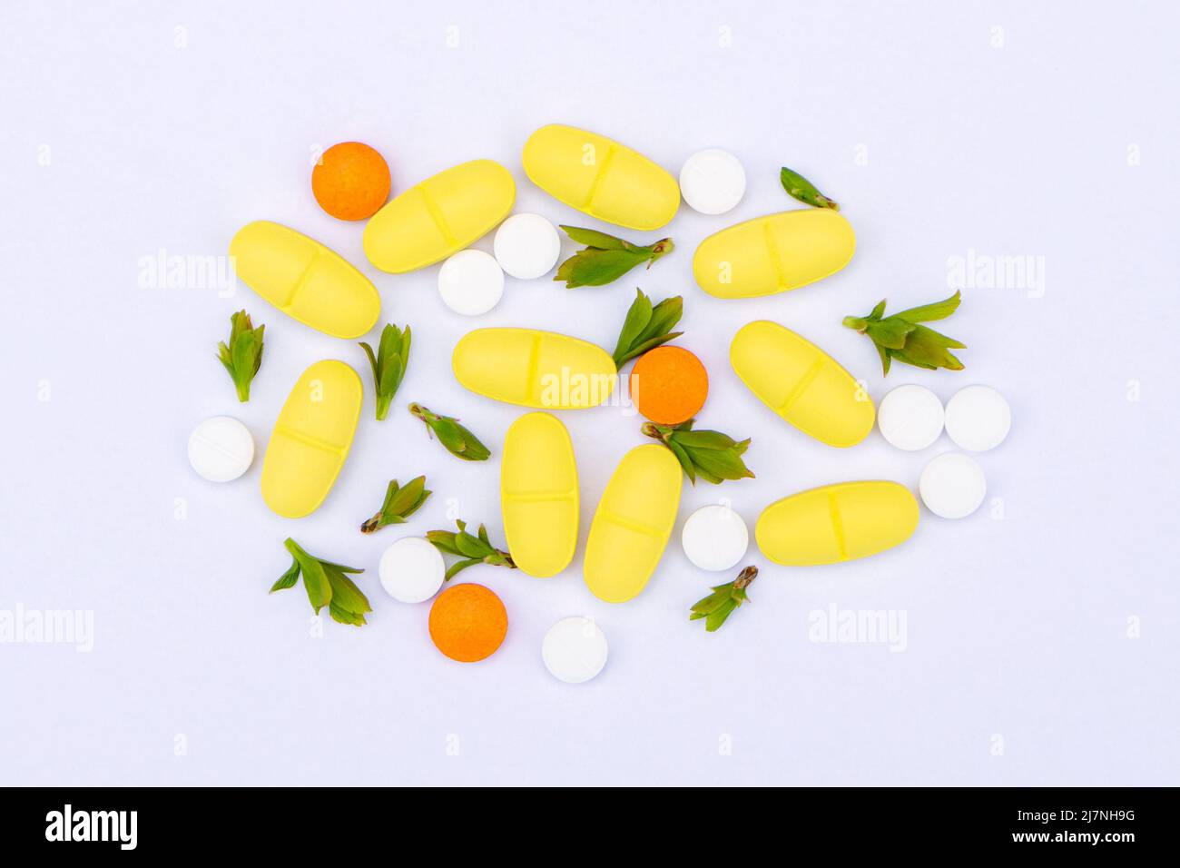 Pills with sprigs of plants on a white background Stock Photo