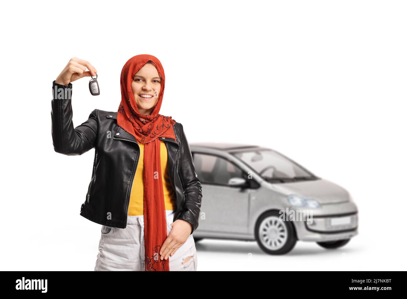 Young woman with a hijab and a leather jacket holding car keys and smiling isolated on white background Stock Photo