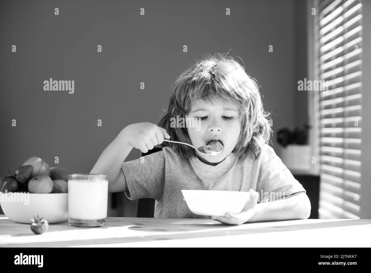 Closeup face of kid eating organic food, yogurt, milk. Child healthy eat. Stock Photo