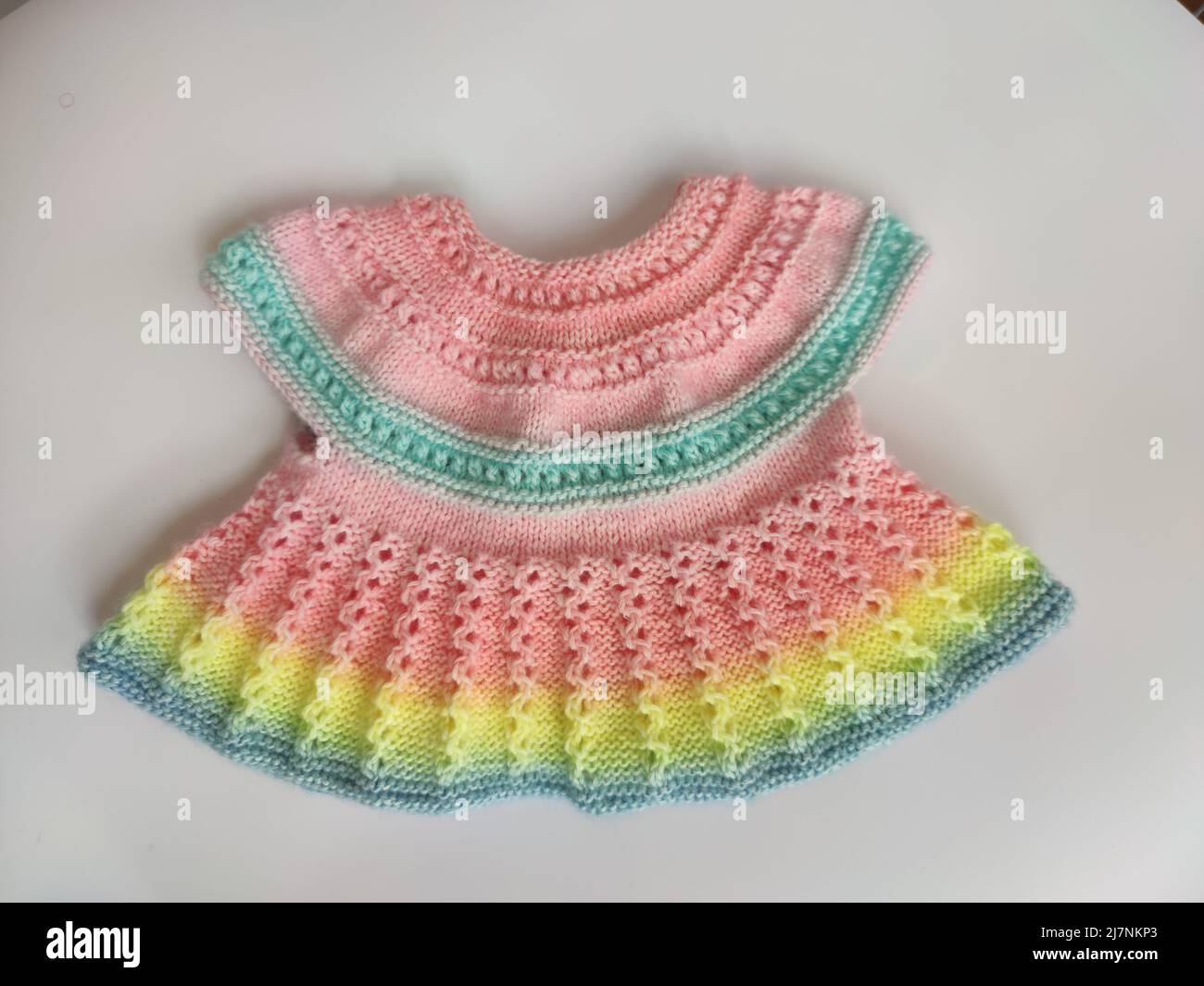Colorful knitted dress for children  background. Baby clothes. Rainbow cute kid's jersey. Fashion for kids. Ideas for handmade Stock Photo