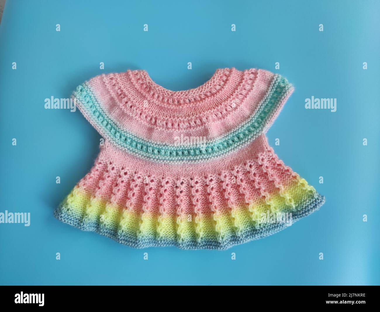 Colorful knitted dress for children  background. Baby clothes. Rainbow cute kid's jersey. Fashion for kids. Ideas for handmade Stock Photo