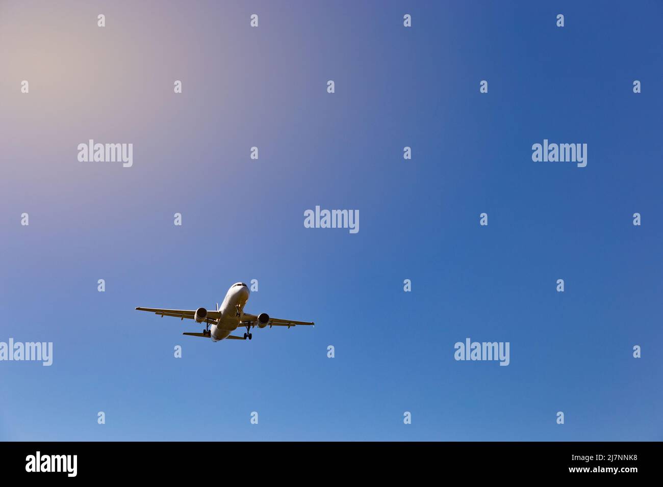 Airplane flying on the blue sky background Stock Photo - Alamy