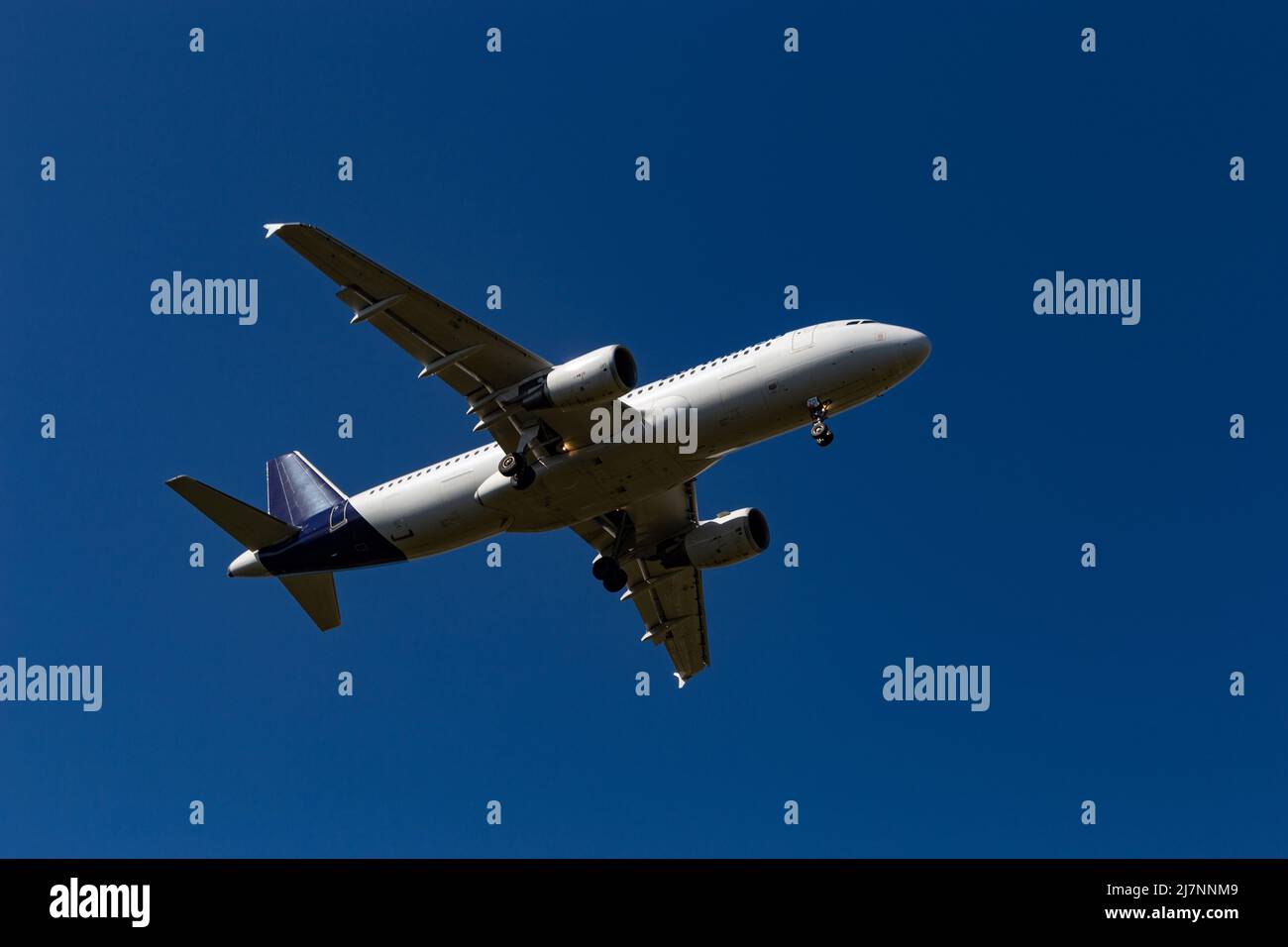 Airplane flying on the blue sky background Stock Photo - Alamy