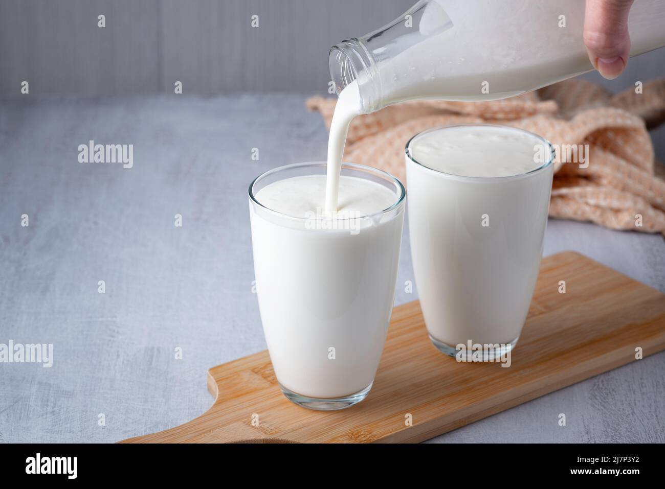 Pouring homemade kefir, buttermilk or yogurt with probiotics Stock