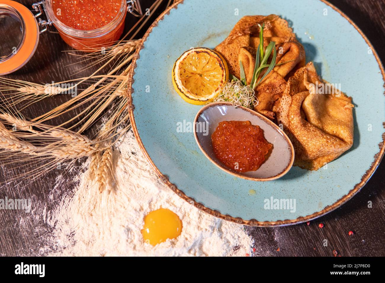 pancakes with red caviar, lemon on the table, egg in flour, whea Stock Photo