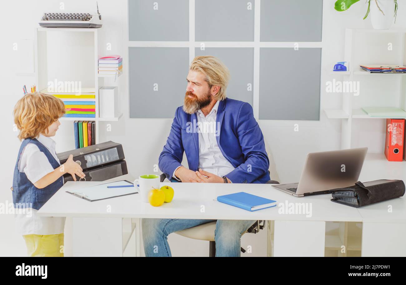 Cute boy kid sitting in office chair self confident like big boss, funny businessman bossy child, director and powerful leader humorous concept Stock Photo