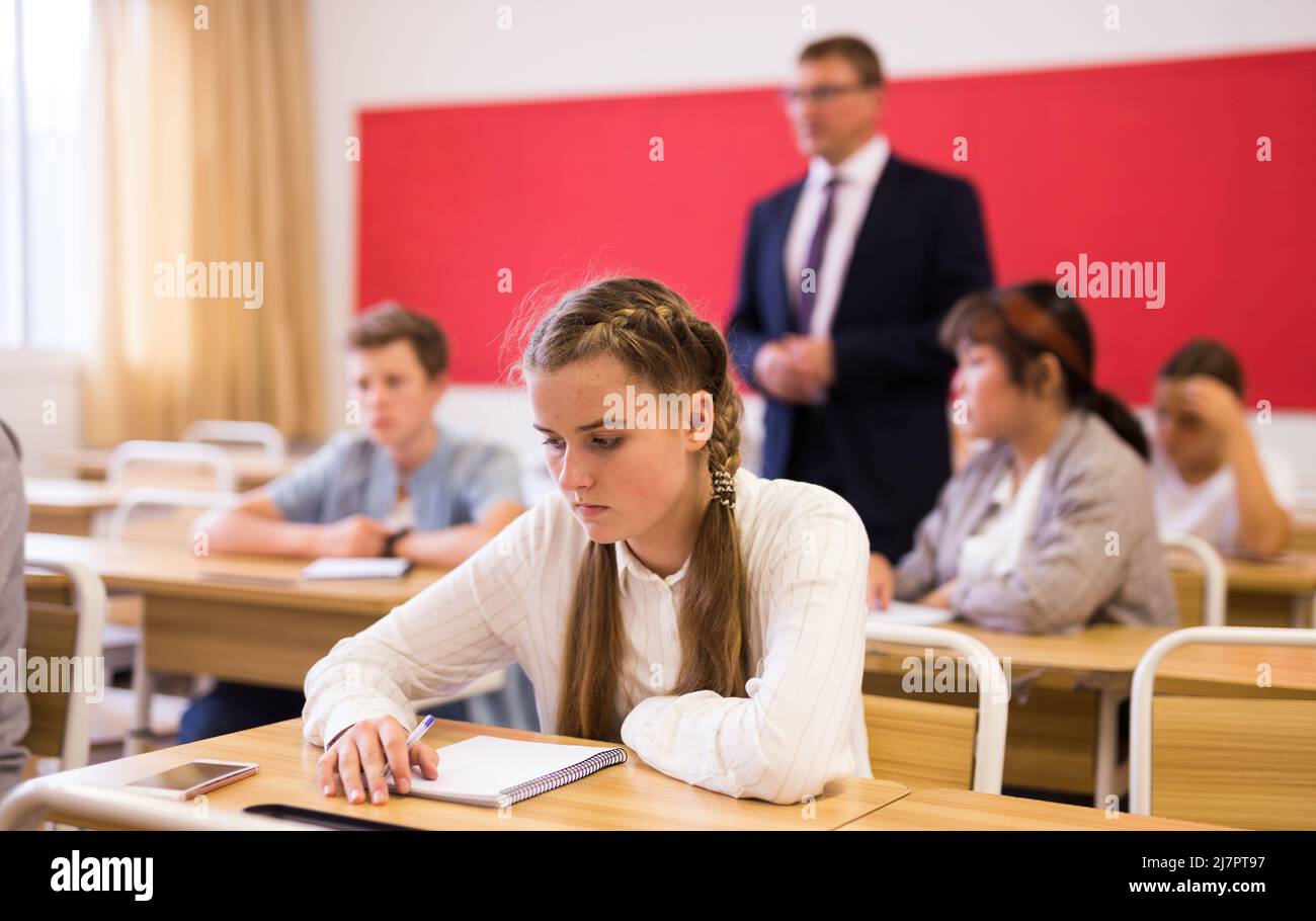 Teen girl sitting at desk in classroom Stock Photo - Alamy