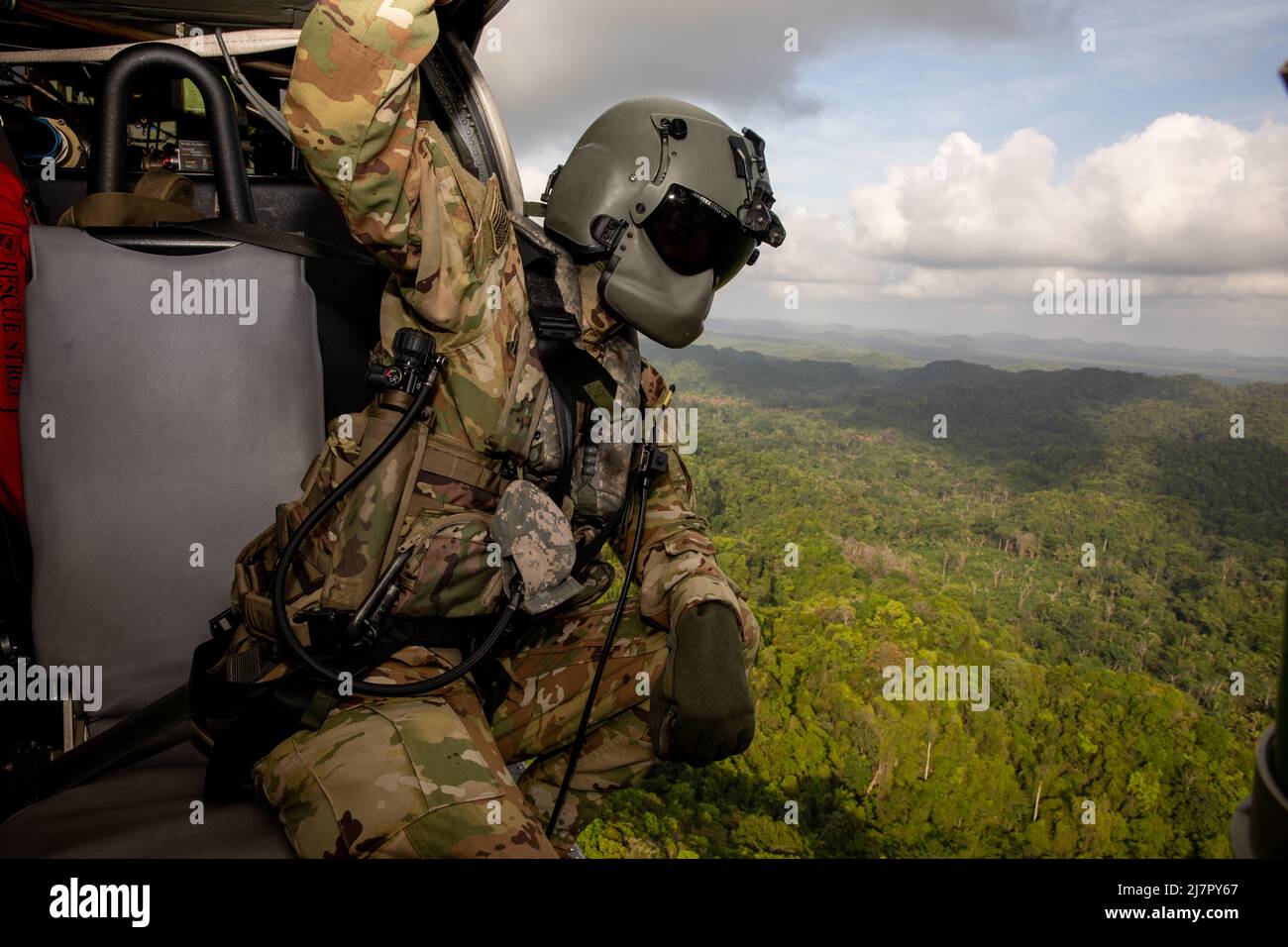 BELIZE CITY, Belize (May 9, 2022) U.S. Army Sgt. Matthew Lynch, a flight paramedic assigned 1st Battalion 228th Aviation Regiment, checks for airborne contacts during a medical evacuation exercise over Belize City, Belize during exercise Tradewinds 2022, May 9, 2022. Tradewinds 2022 is a multinational exercise designed to expand the Caribbean region’s capability to mitigate, plan for, and respond to crises; increase regional training capacity and interoperability; develop new and refine existing standard operating procedures (SOPs); enhance ability to defend exclusive economic zones (EEZ); and Stock Photo