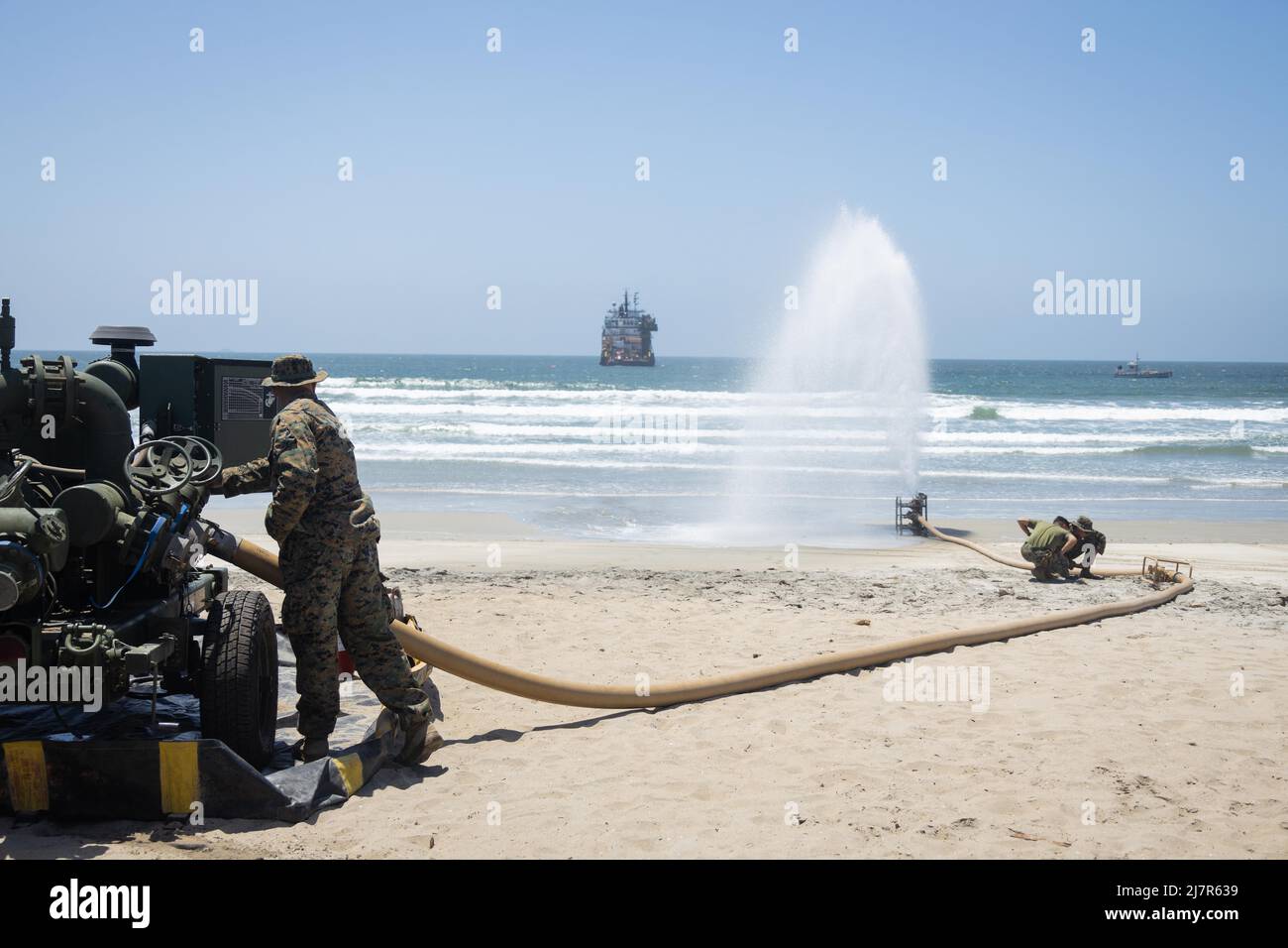 U.S. Marines with Bulk Fuel Company, 7th Engineer Support Battalion, 1st Marine Logistics Group, pump excess sea water out of a liquid bladder during tactical bulk fuel operations on Silver Strand State Beach, California, May 4, 2022. Demonstrations of both existing and new bulk liquid distribution systems were utilized to aid development of fuel distribution in contested littoral environments. (U.S. Marine Corps photo by Sgt. Maximiliano Rosas) Stock Photo